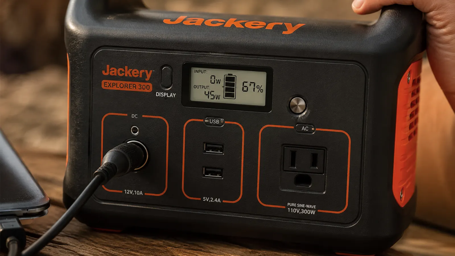 Close-up of the Jackery Explorer 300 display showing remaining battery percentage and wattage draw while charging a laptop